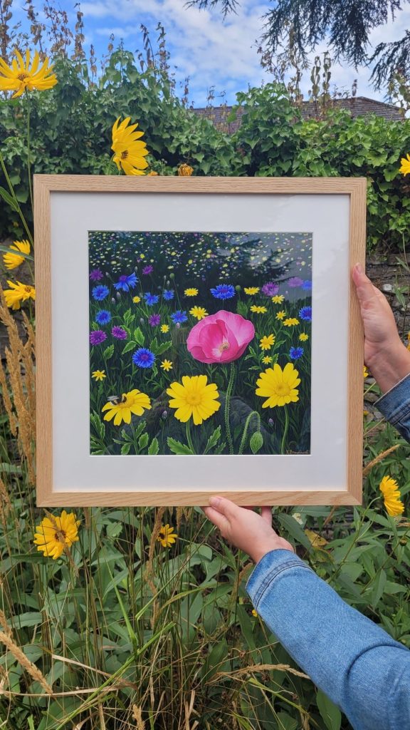 Kate Broadhurst Rodd holding up an image of her wildflower painting.